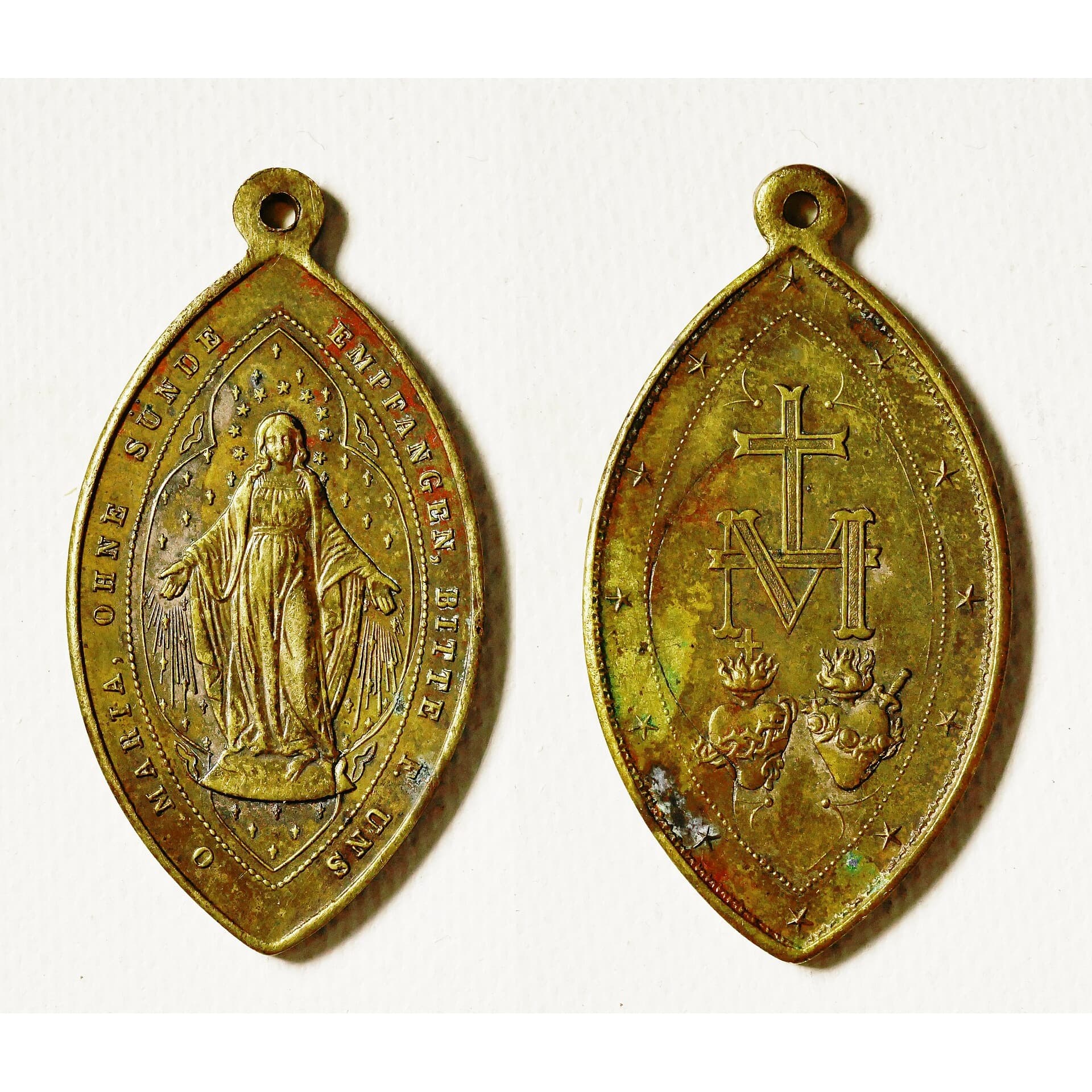 Front and back of an oval Miraculous Medal on a white background
